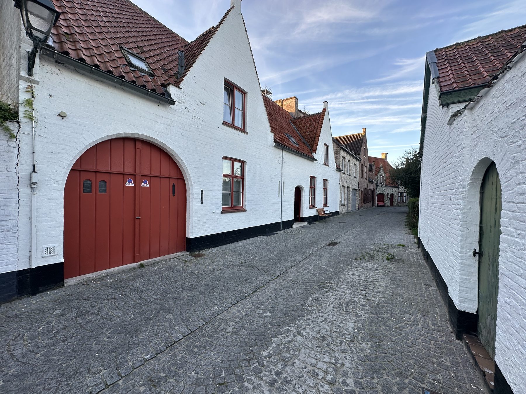 De Speystraat met kasseien en witte gevels, de rode garagepoort links