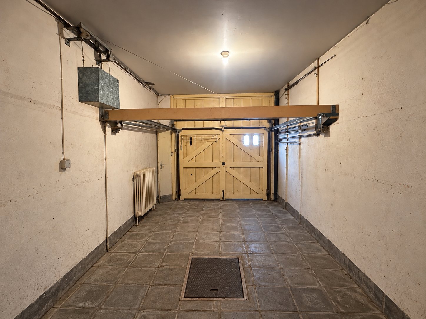 Le garage vide avec porte en bois et radiateur