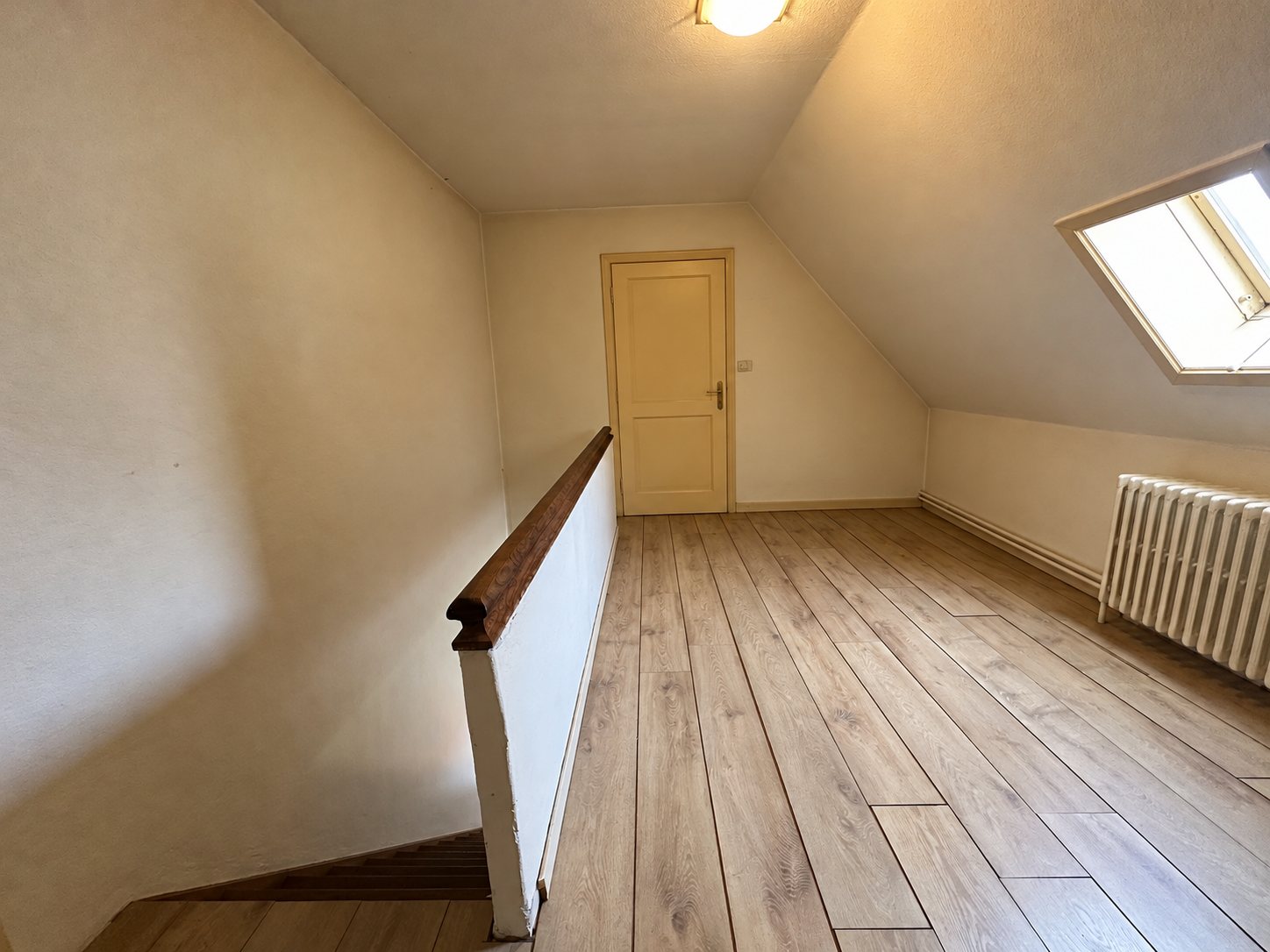 Le palier vide avec fenêtre de toit et rampe en bois