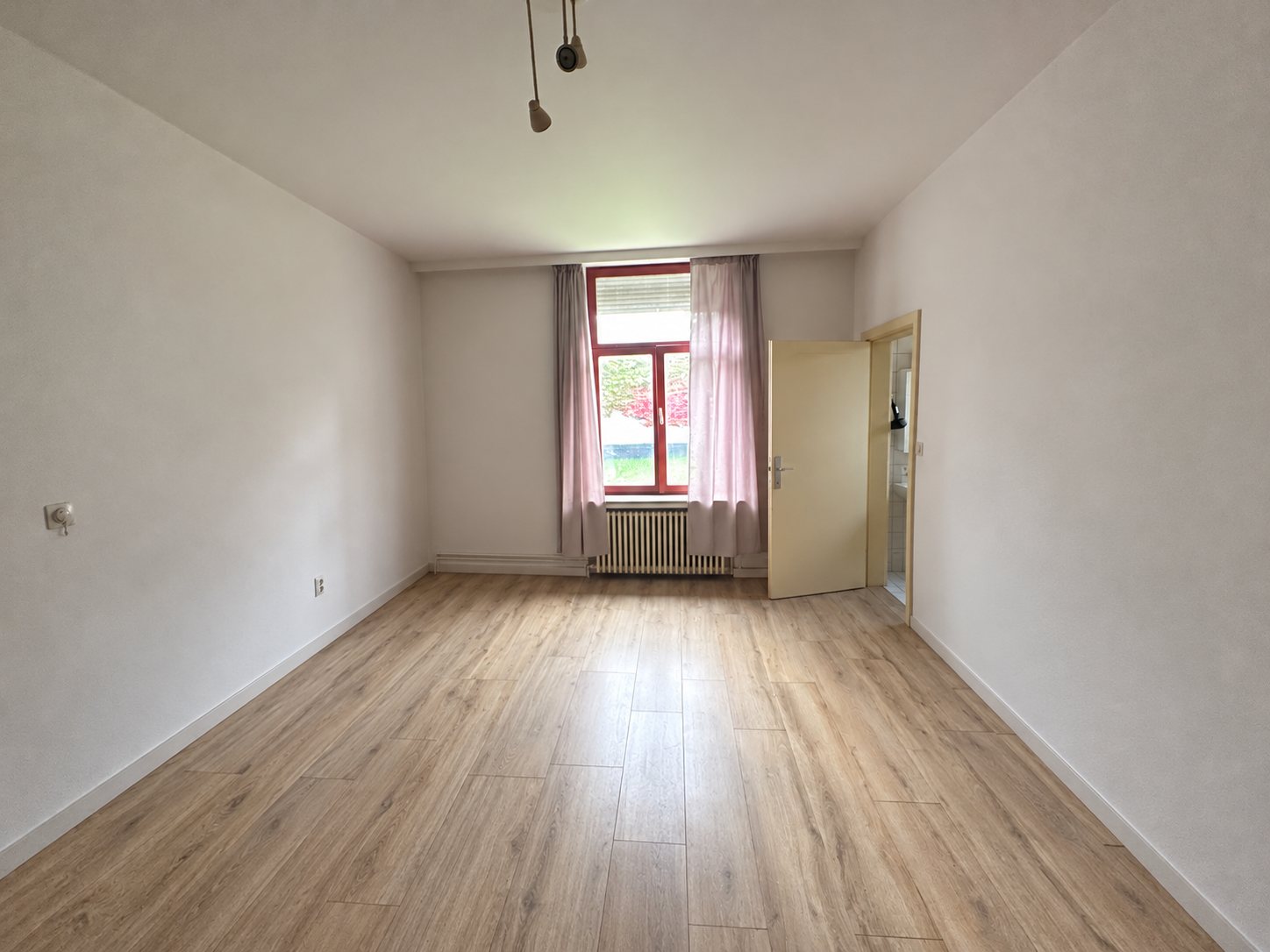 De lege slaapkamer met raam en deur