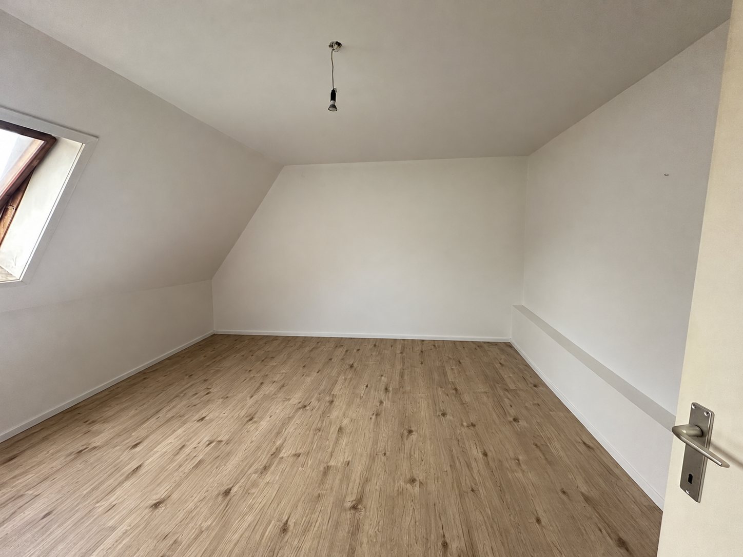 De lege kamer onder het dak met dakraam