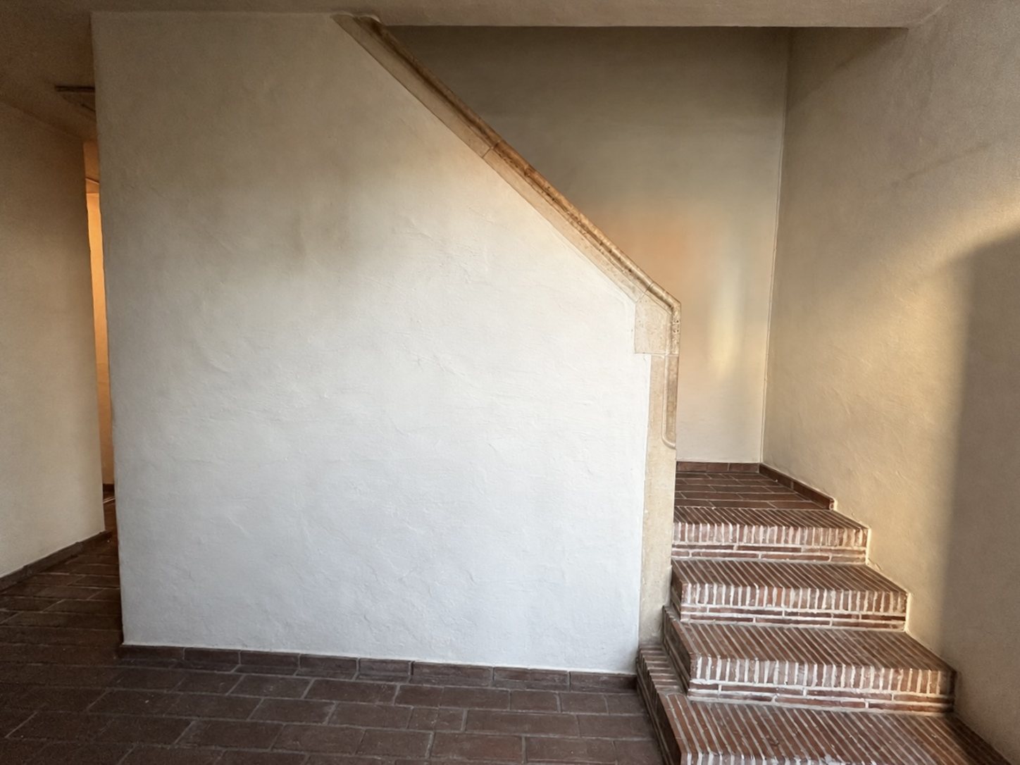 L'entrée vide avec escalier en briques et un mur clair