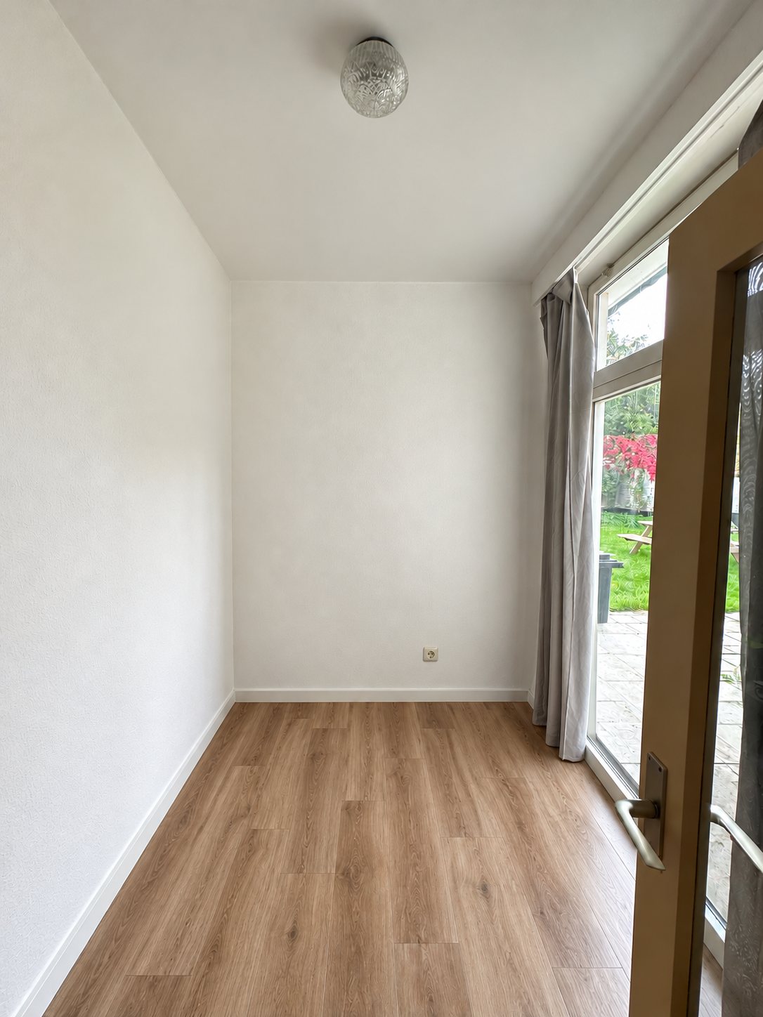 De lege ruimte met glazen deur naar het terras